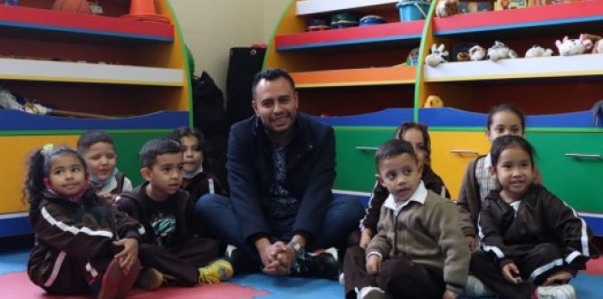 Foto alcalde local Óscar Ramos Calderon en jardín infantil rodeado de niños